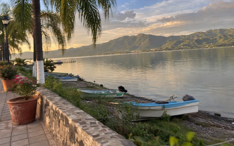 Lake Chapala shoreline in Ajijic with fishing boats and mountains across the water