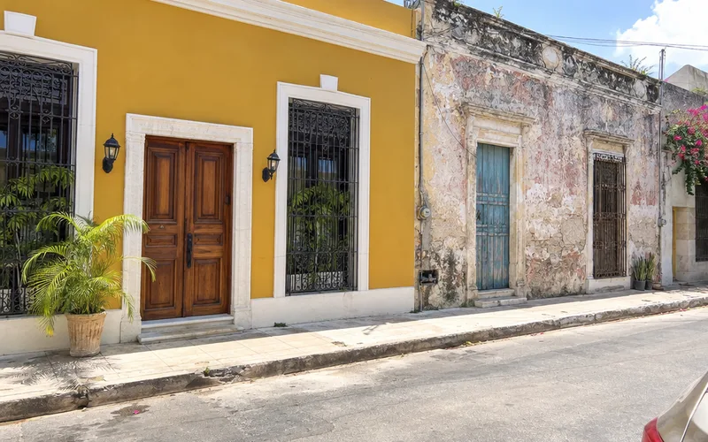 Freshly restored colonial house in Mérida with a bright painted facade next to an older weathered house