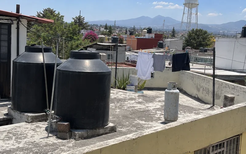 Black water storage tanks and a laundry line on the rooftop of a Mexican apartment building